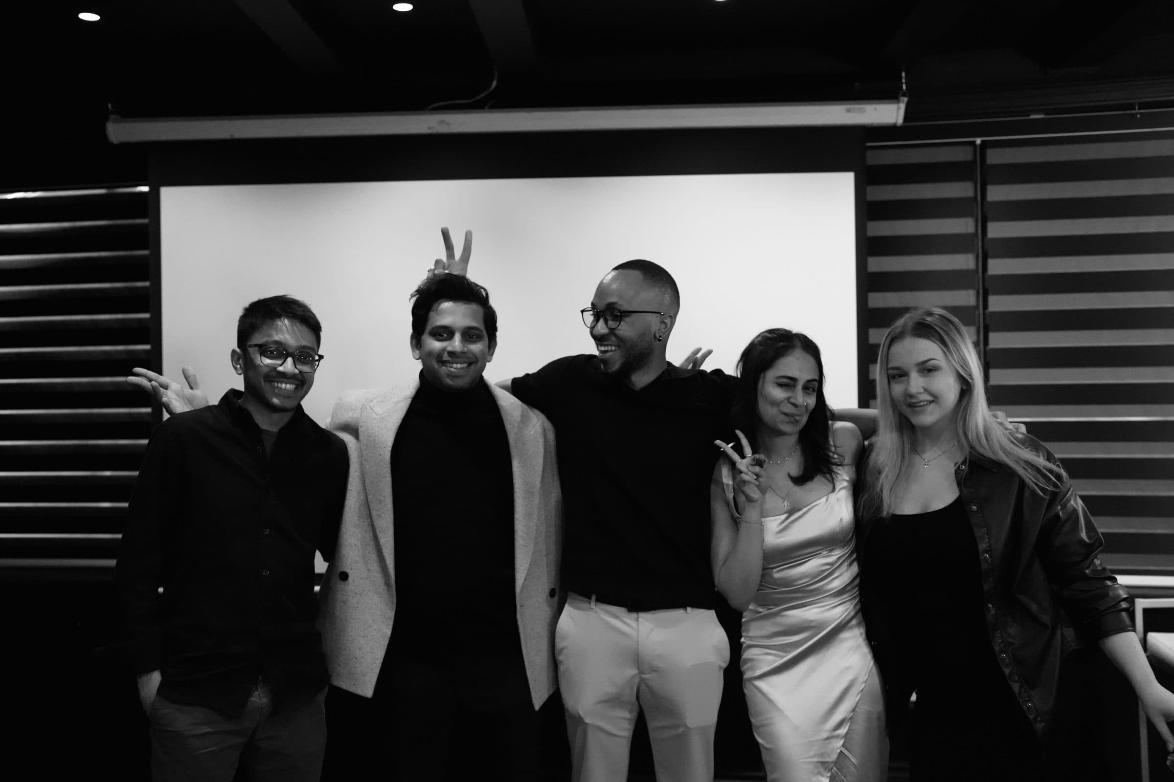 Five members of the team laughing together for a group photo